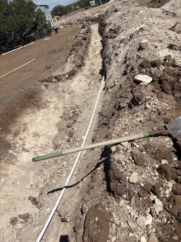 A utility trench cut through rocky high-desert ground in northeastern Arizona