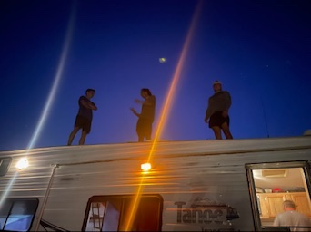 Family enjoying a night outside beside their camper at West End Ranch