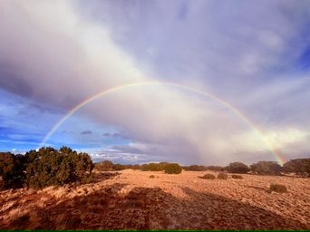 A full rainbow stretching over the open landscape at West End Ranch