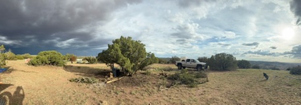Wide view of open camping land beneath a dramatic Arizona sky
